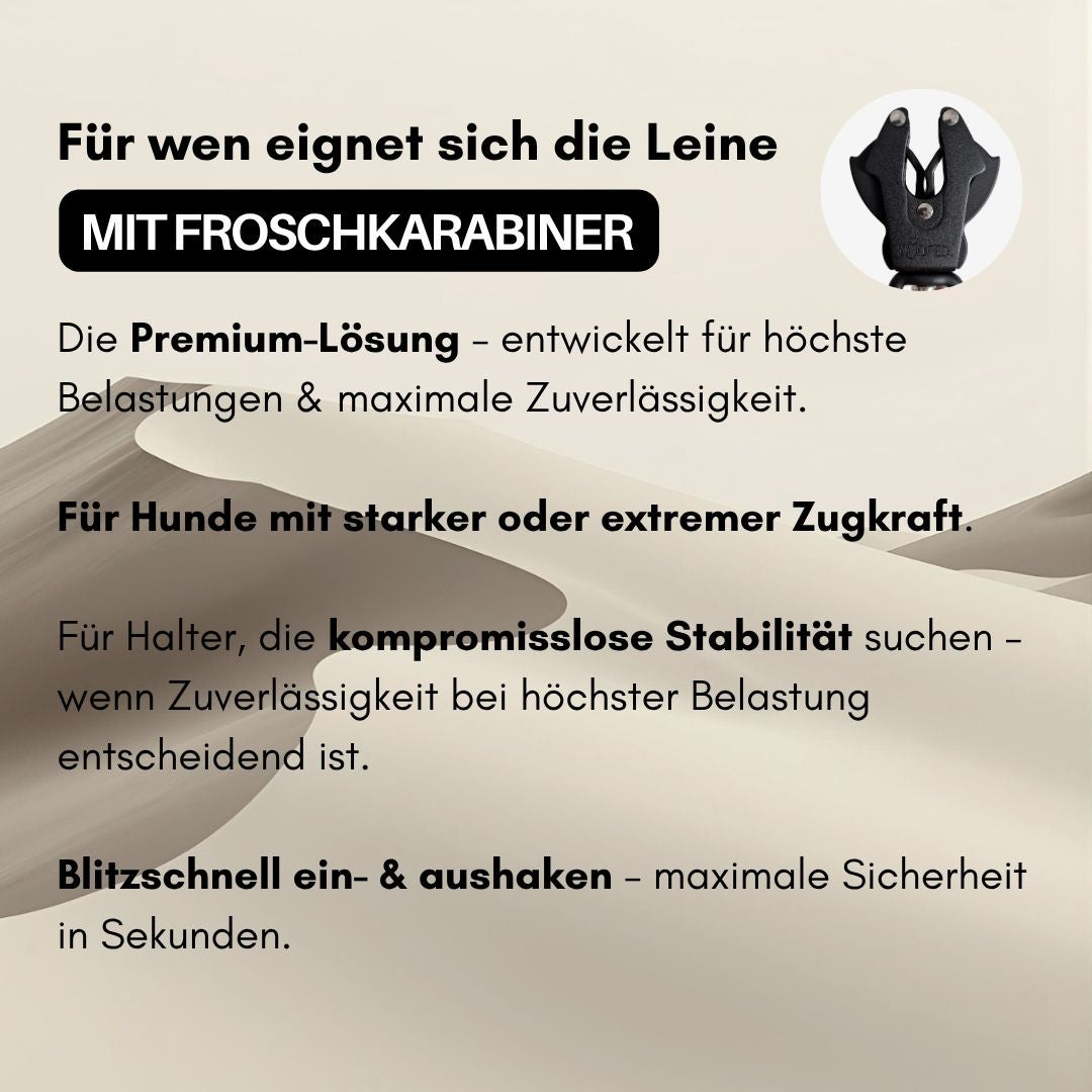 Schwarze Nahaufnahme des Froschkarabiners der Führleine, kreisförmig auf sandfarbenem Dünenhintergrund mit Werbetext
