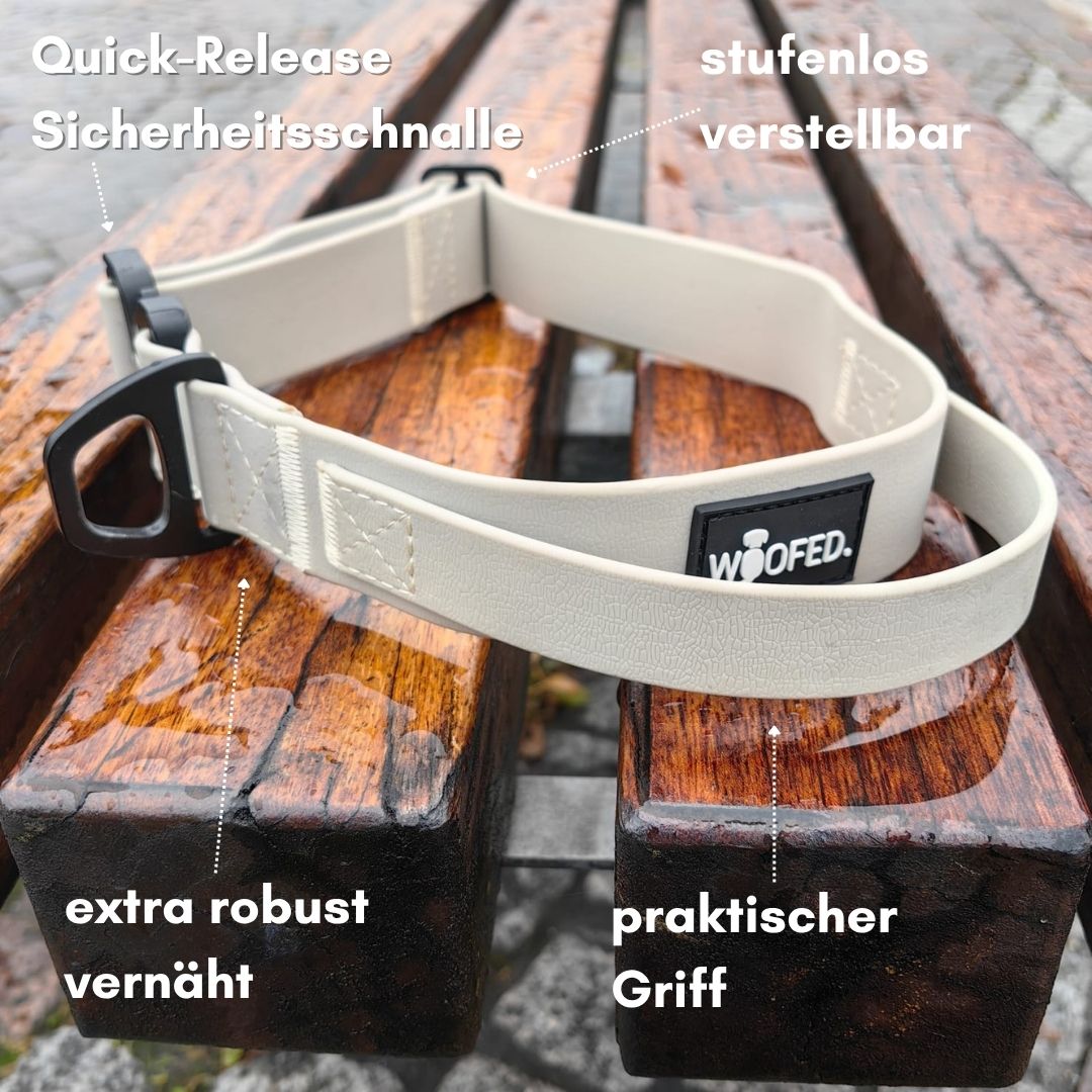 Sandfarbenes verstellbares WOOFLEX Halsband mit schwarzer Sicherheitsschnalle und Griff auf nasser Holzbank