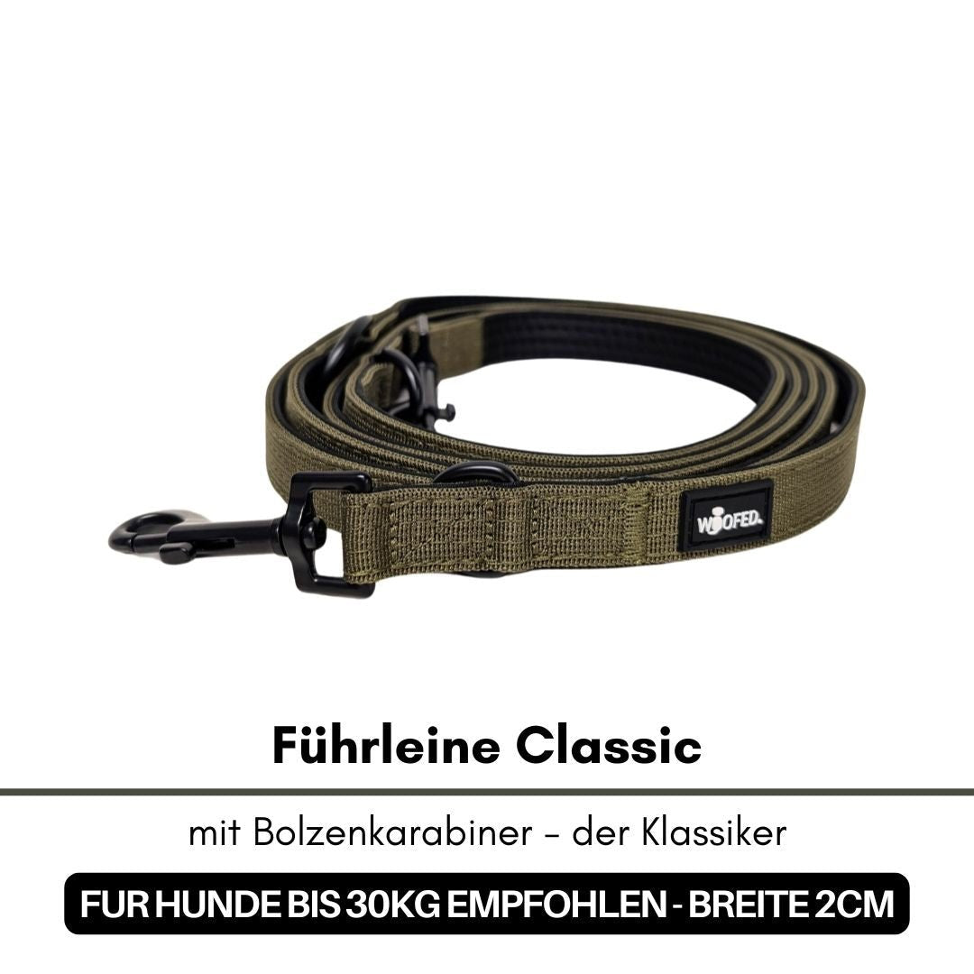 Military‑olive Nylon-Führleine Classic, aufgerollt, schwarze Bolzenkarabiner und WOOFED-Label, flache Ansicht