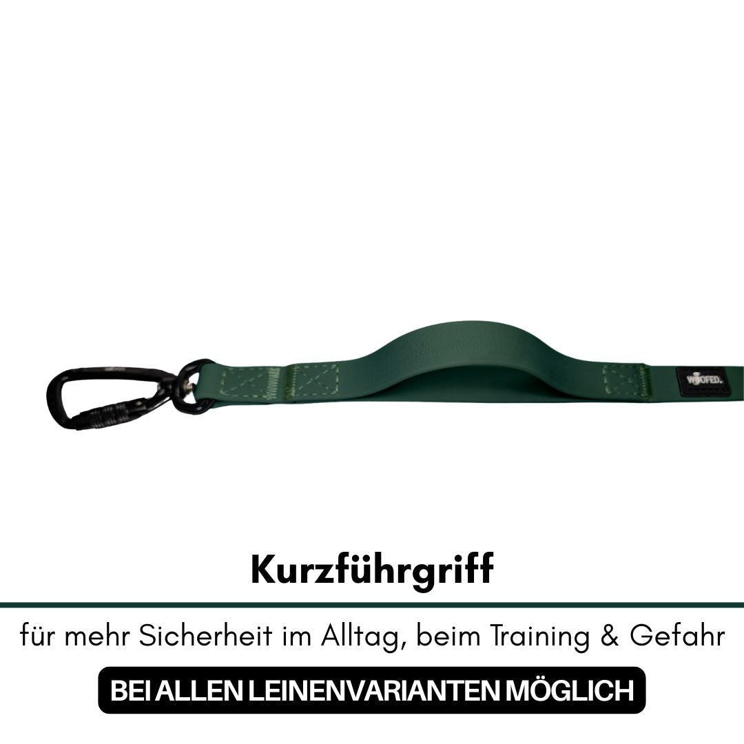 Grüner Kurzführgriff der Hundeleine, Seitenansicht mit gebogenem Griff und schwarzem Karabiner auf weißem Hintergrund
