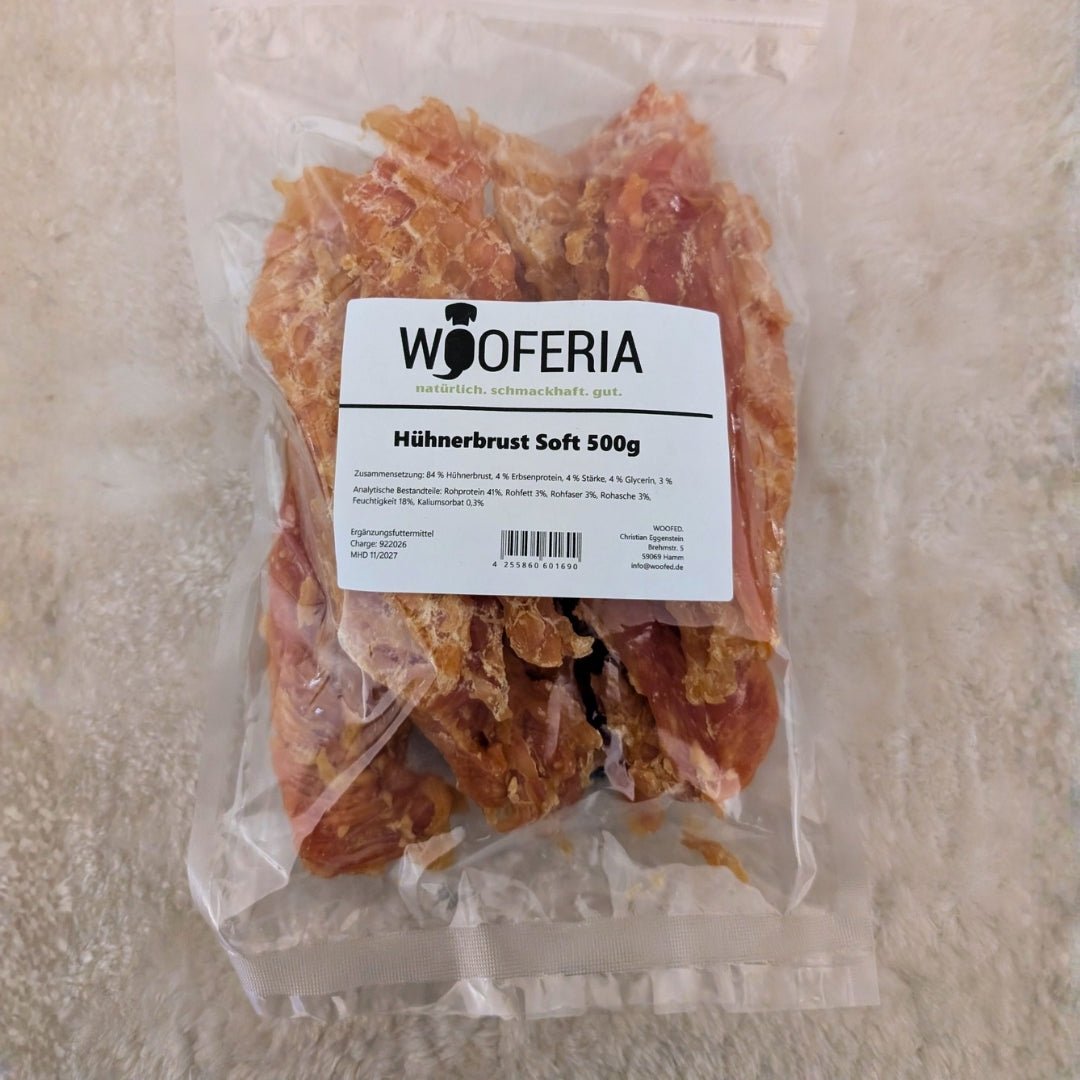 Klare Vakuumtüte mit getrockneten Hühnerbrust‑Streifen und weißem WOOFERIA‑Etikett 'Hühnerbrust Soft 500g', Draufsicht