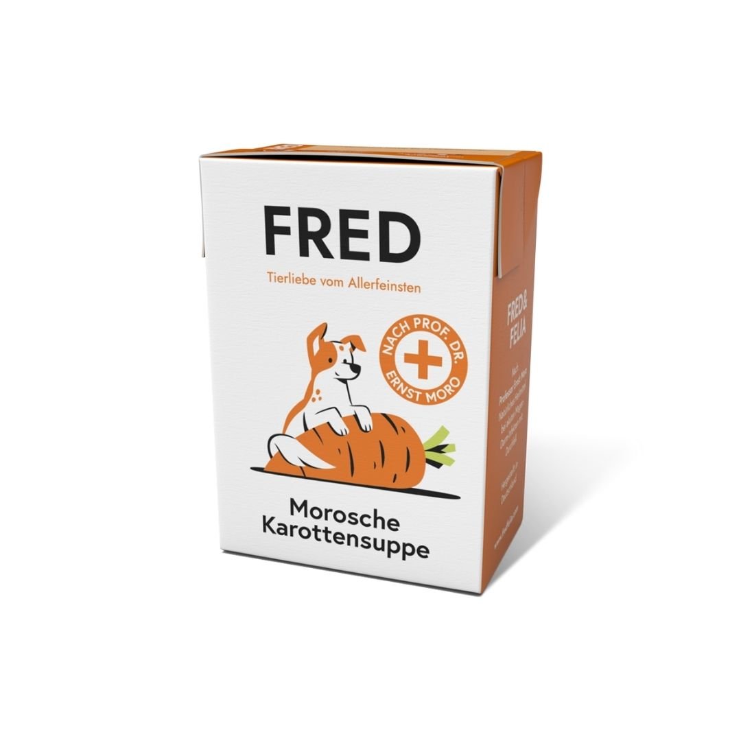Weiße-orange Kartonpackung, 3/4-Ansicht, Schriftzug "FRED", Hund-auf-Karotte-Illustration und Text "Morosche Karottensuppe"