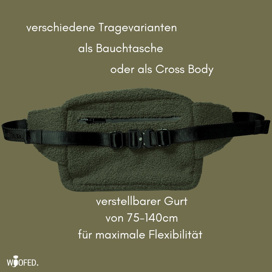 Olivefarbene Teddy-Gassitasche flach liegend, sichtbarer Reißverschluss vorne, schwarzer verstellbarer Gurt mit Klickverschlü