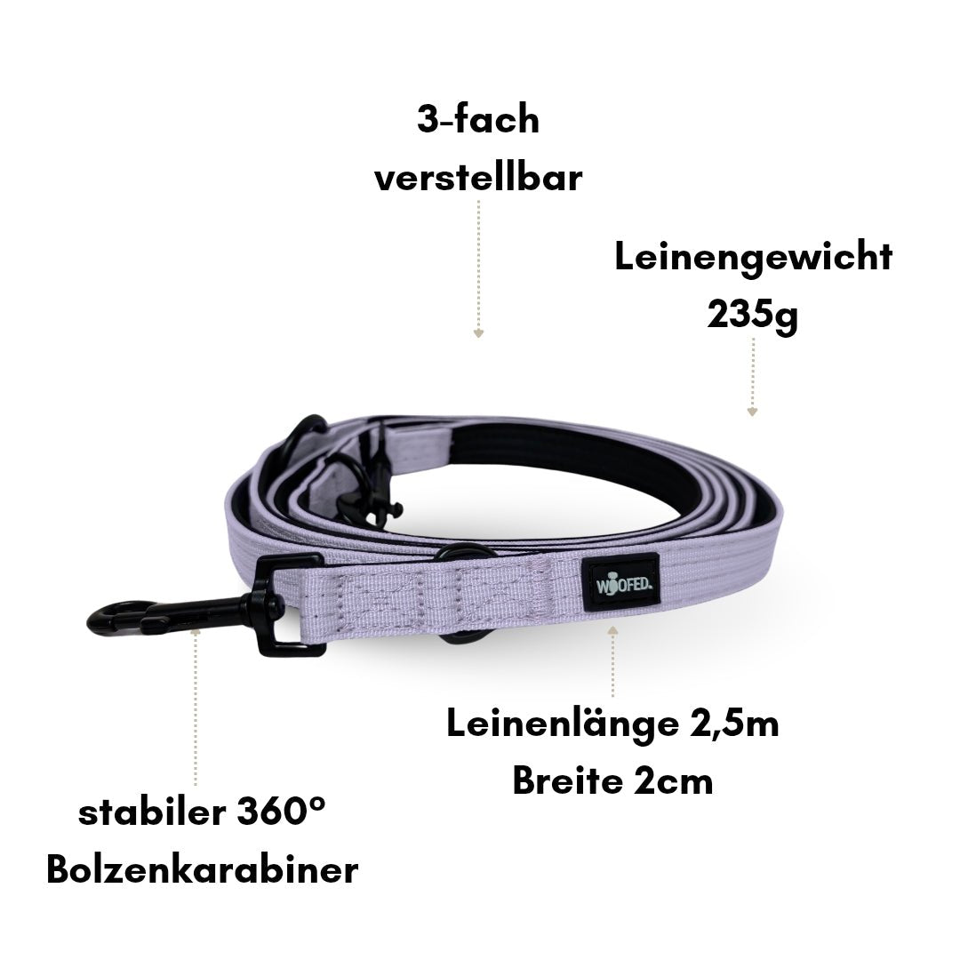 Aufgerollte lilafarbene Nylon-Führleine, schräge Draufsicht, schwarzer 360°-Bolzenkarabiner und WOOFED-Label sichtbar
