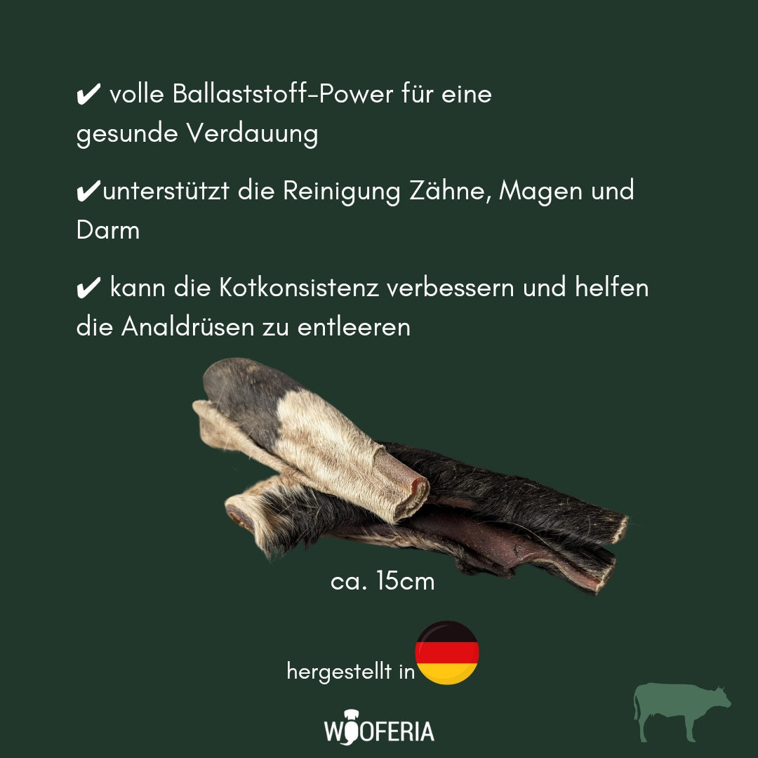 Gerollte Rinderkopfhaut mit Fell, schwarze und beige Fellpartien, mehrere Streifen seitliche Ansicht auf grünem Hintergrund