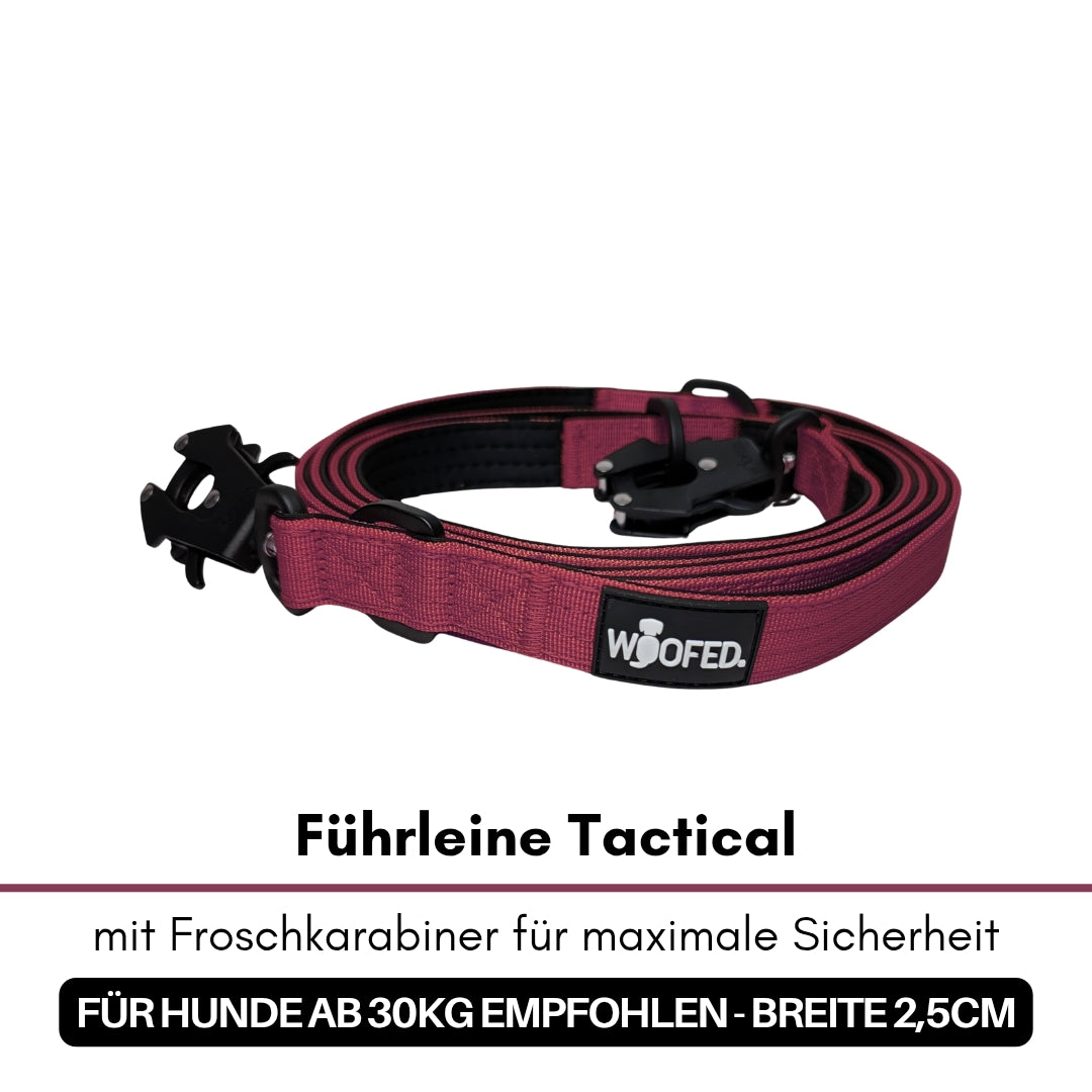 Aufgerollte bordeauxfarbene Tactical‑Führleine mit schwarzem Froschkarabiner und sichtbarem WOOFED‑Logo