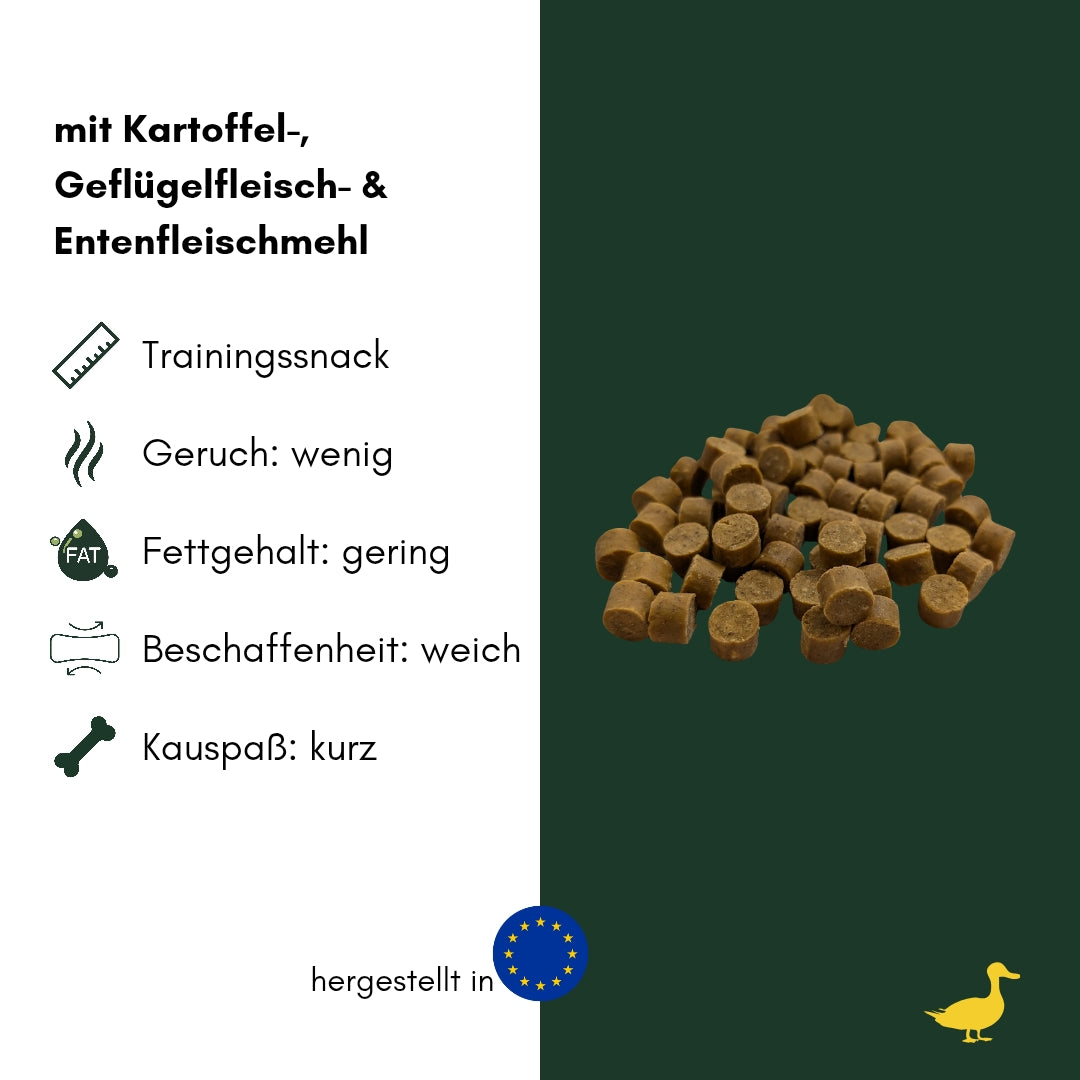 Ente Softies: Haufen kleiner brauner, zylinderförmiger Leckerlis, leicht von oben fotografiert vor dunkelgrünem Hintergrund