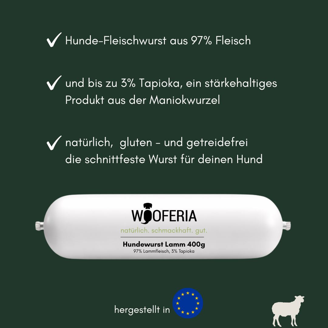 Weiße zylindrische Hundewurst mit WOOFERIA‑Etikett Hundewurst Lamm 400g, auf dunkelgrünem Hintergrund mit EU‑Flagge und Schaf