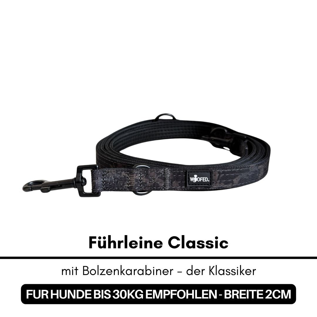 Black Camo Führleine (Classic), flach aufgerollt mit Bolzenkarabiner links und sichtbarem WOOFED-Label
