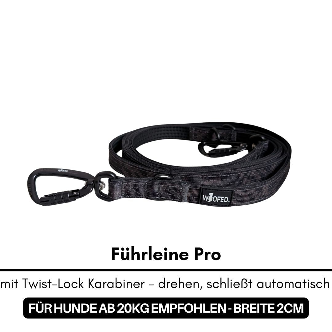 Aufgerollte schwarze Camo-Hundeleine mit Twist-Lock-Karabiner und WOOFED-Logo
