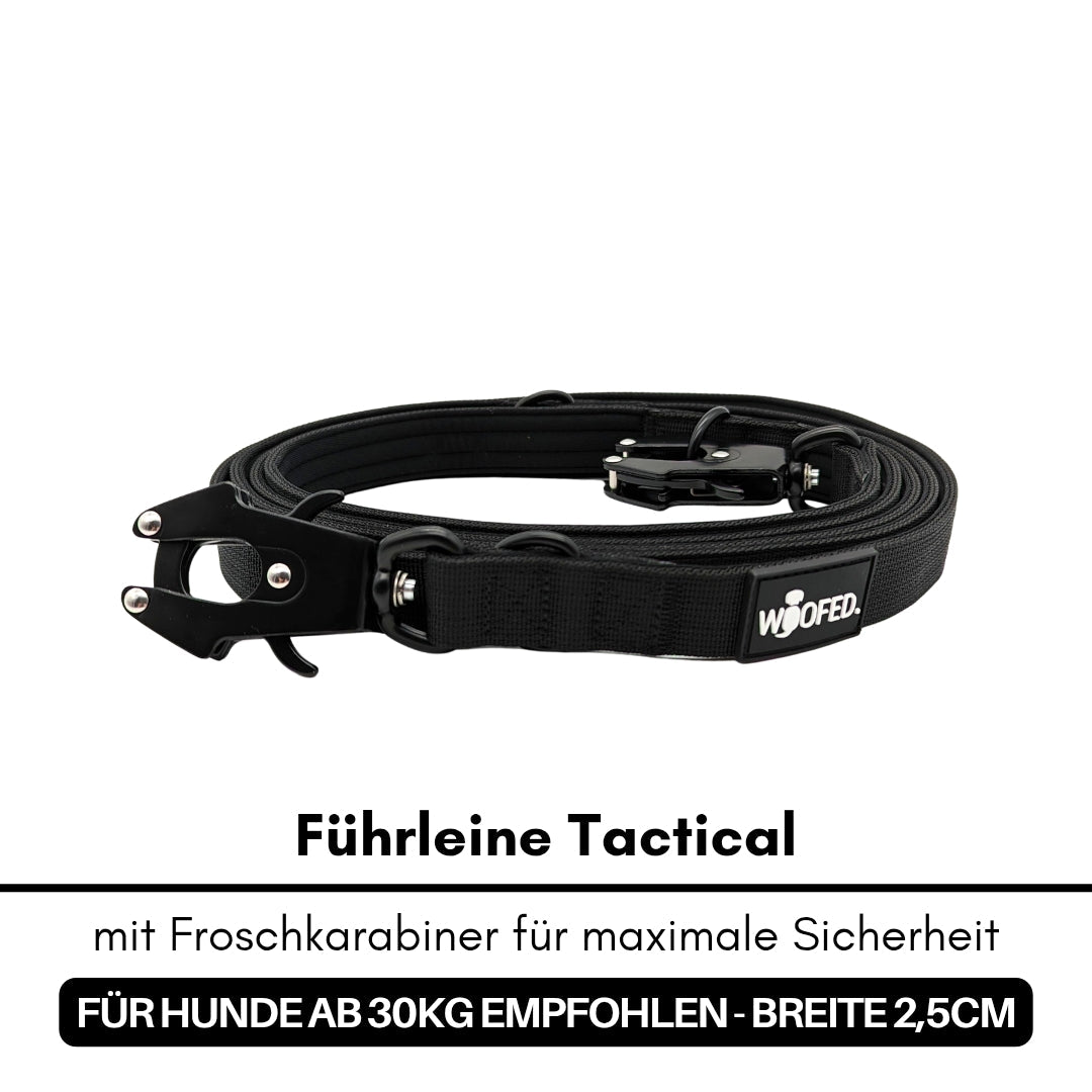 Schwarze, aufgerollte Tactical-Führleine mit Froschkarabiner, Metallverschluss und sichtbarem WOOFED‑Logo, Seitenansicht