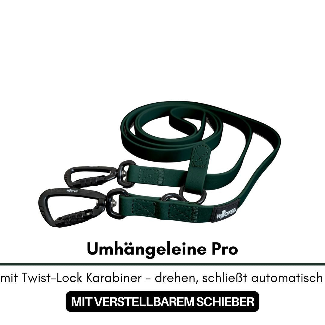 Umhängeleine Pro Hunting Green, dunkelgrünes flaches Band, aufgerollt, zwei schwarze Twist‑Lock‑Karabiner, mit Schieber