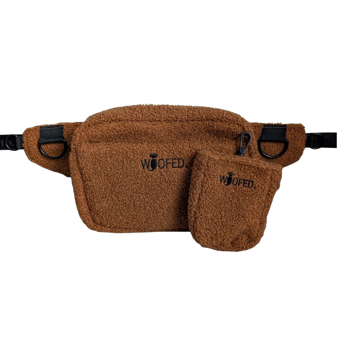 Braune Teddy-Gassitasche querliegend mit abnehmbarem Leckerlibeutel, schwarzem WOOFED-Logo, Reißverschluss und D-Ringen