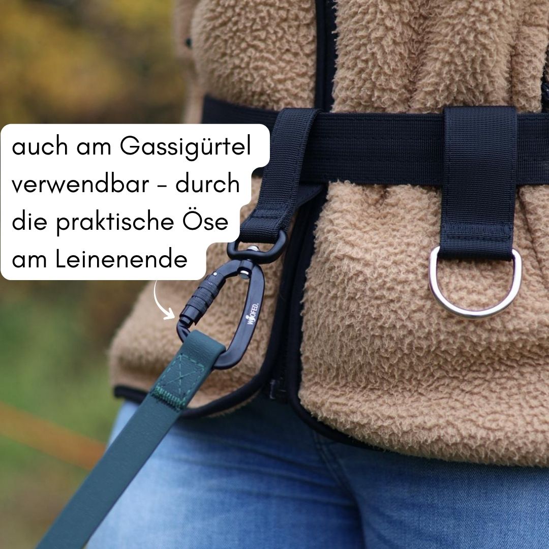 Nahaufnahme der dunkelgrünen WOOFLEX Schleppleine (Leinenende) mit schwarzem Karabiner am Gassigürtel