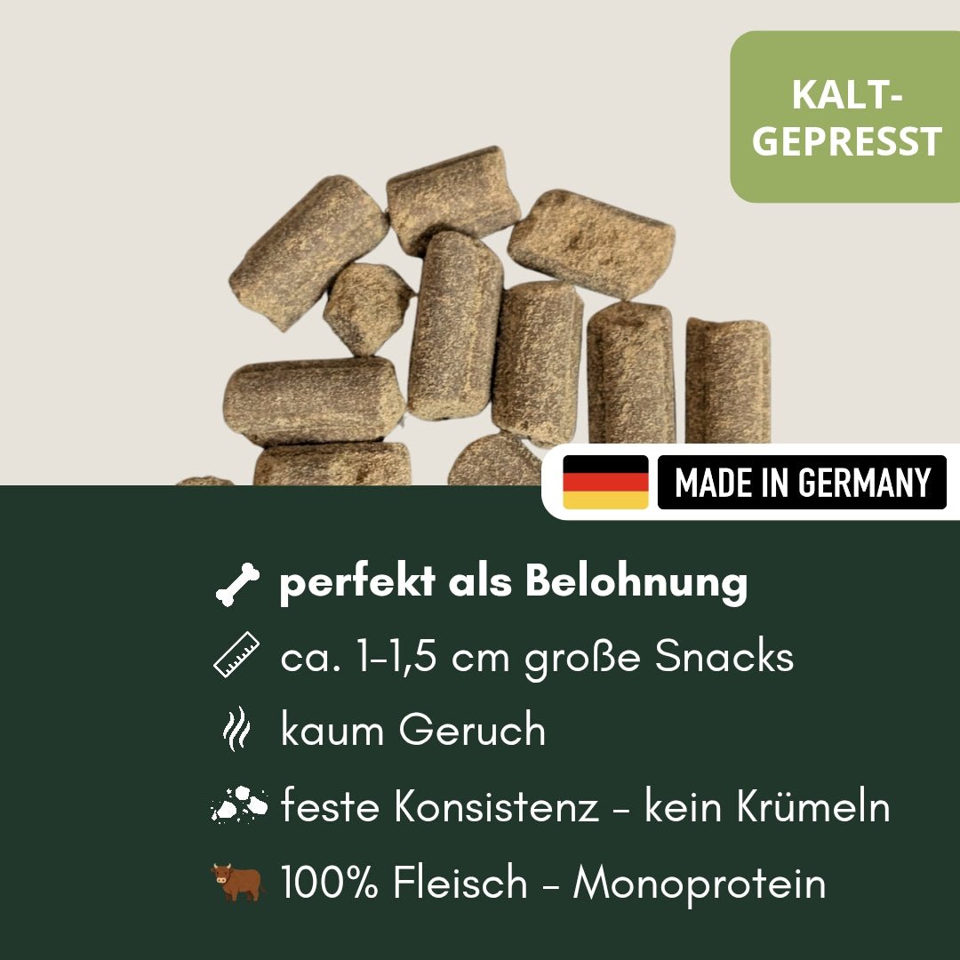 Nahaufnahme brauner zylindrischer kaltgepresster Rinder-Hundesnacks auf hellem Hintergrund mit Made-in-Germany-Label