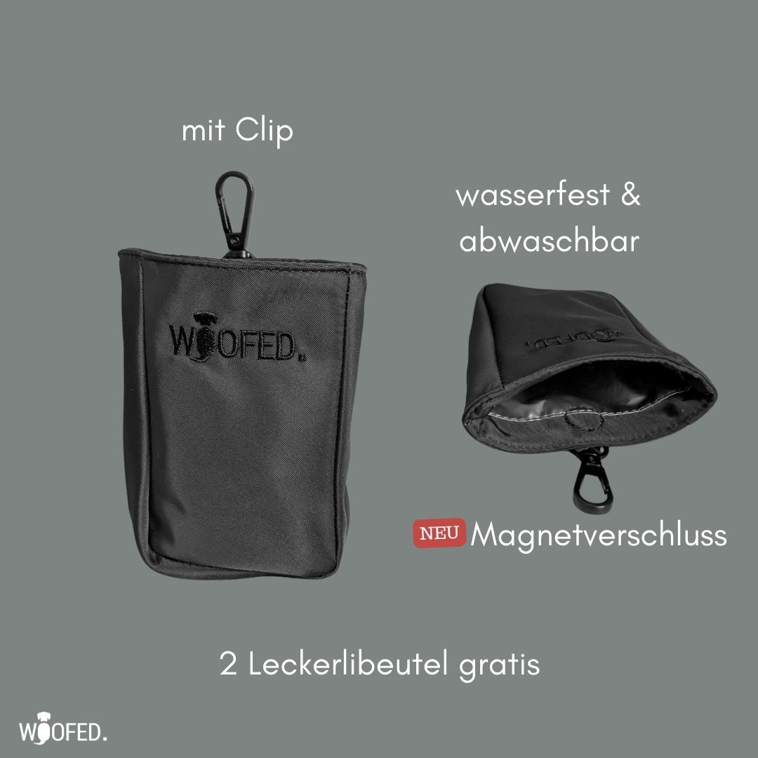 Zwei schwarze Leckerlibeutel mit Karabiner-Clip, einer geöffnet mit wasserfester Innenbeschichtung, bestickt „WOOFED.“