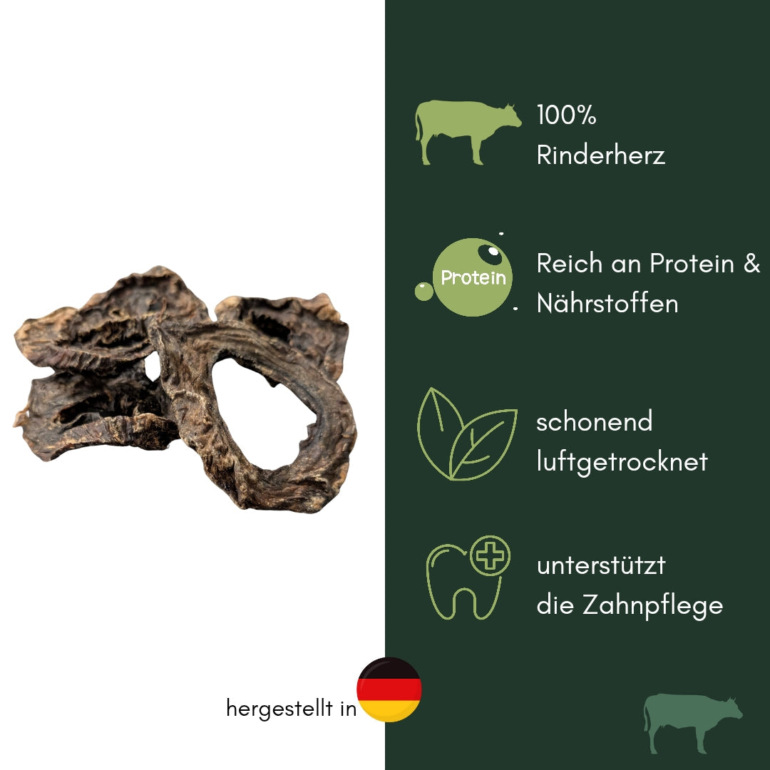 Getrocknete dunkelbraune, ringförmige Rinderherzstücke gestapelt auf weißem Hintergrund, daneben grünes Info-Panel