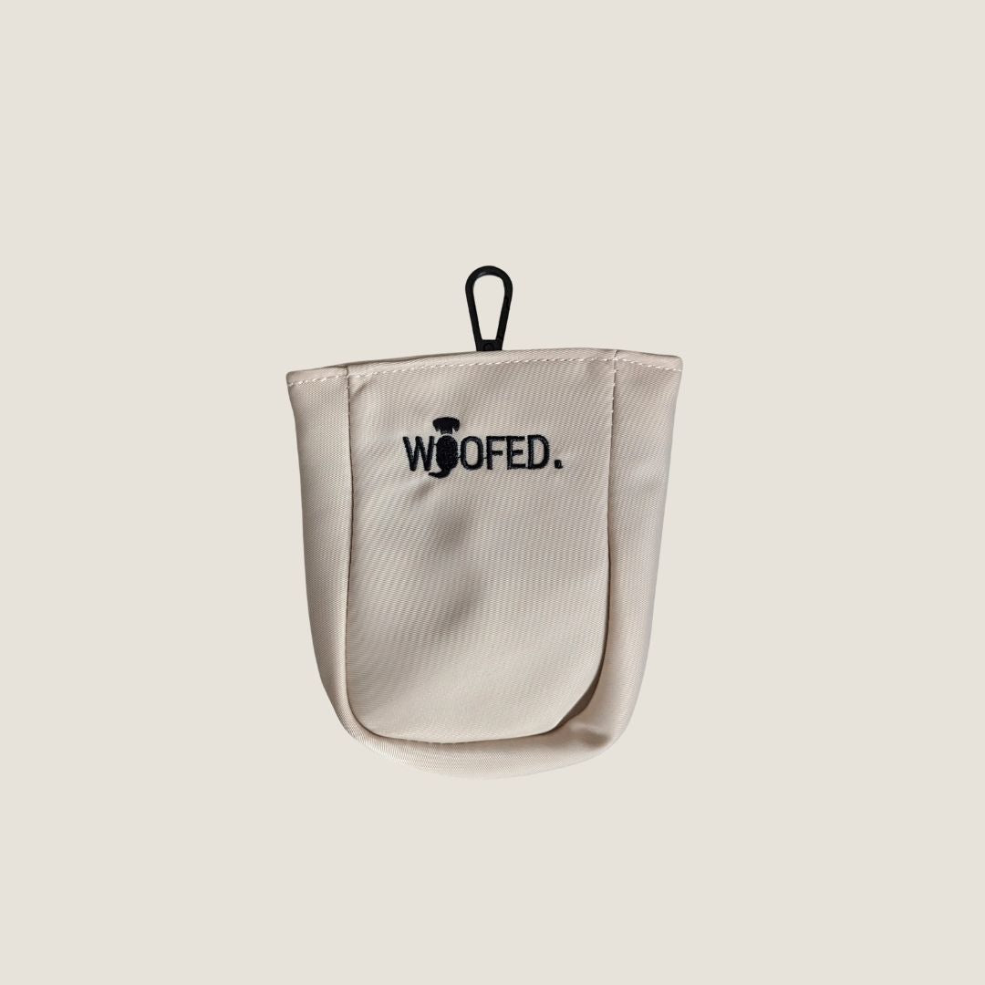 Beiger Leckerlibeutel, Frontalansicht mit schwarzem Clip oben und gesticktem "WOOFED."-Logo