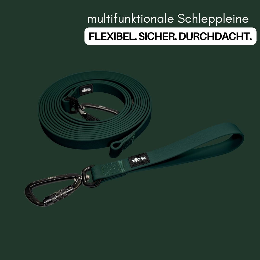 Gewickelte dunkelgrüne Schleppleine mit breiter Handschlaufe und schwarzem Schraubkarabiner, Draufsicht