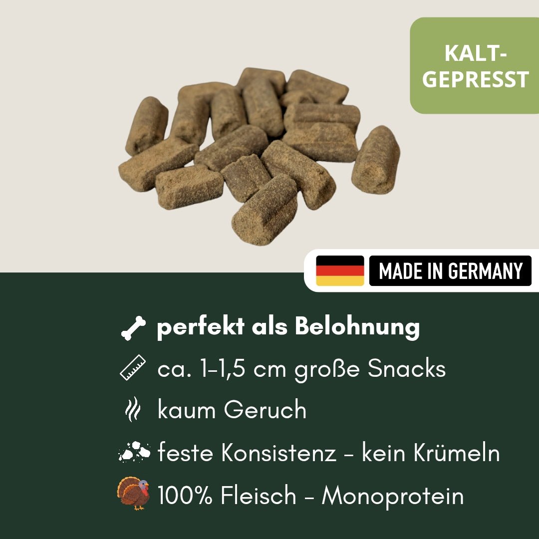 Nahaufnahme kaltgepresster brauner Truthahn-Hundesnacks, rechteckige Stücke, schräge Vorderansicht mit Made-in-Germany