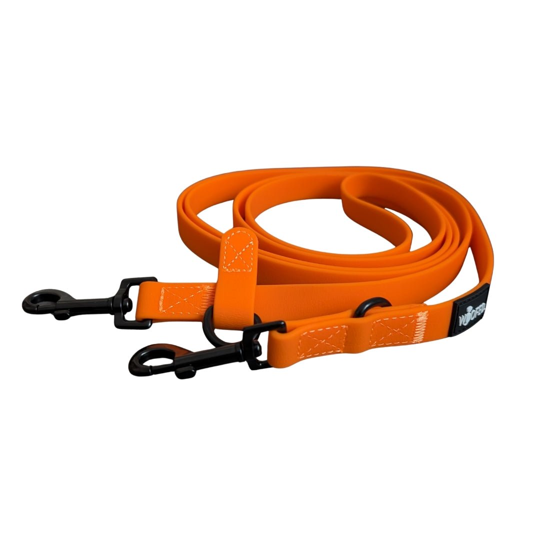 Aufgerollte WOOFLEX Umhängeleine in Sunset Orange mit zwei schwarzen Clips, verstellbarem Schieber und sichtbaren Ziernähten