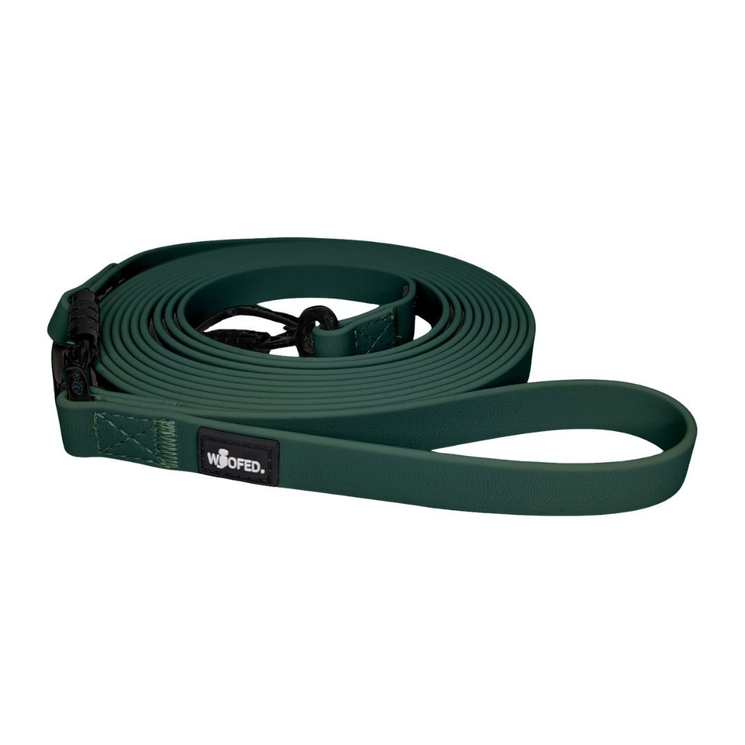 Aufgerollte dunkelgrüne WOOFLEX Schleppleine (Hunting Green) mit Handschlaufe, schwarzem Karabiner und Logo